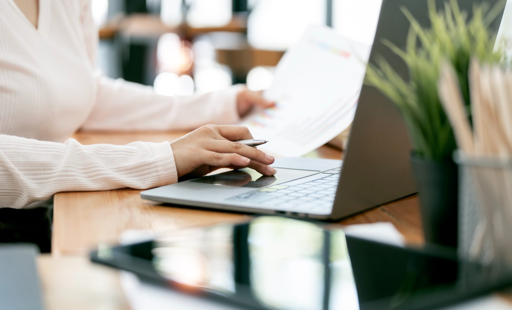 Consultante travaillant sur un ordinateur portable, documents en main